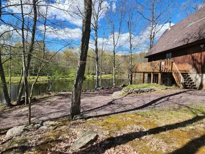 a barn in the woods next to a body of water at Pocono Mountain Retreat in Cresco