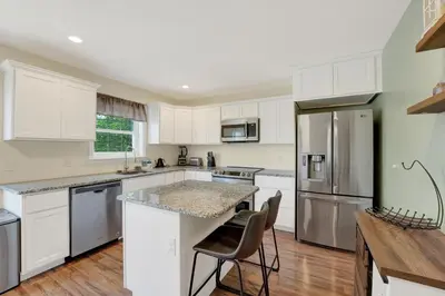 a kitchen with white cabinets and stainless steel appliances at Chic Modern Townhouse 4BR 4B in Wilmington