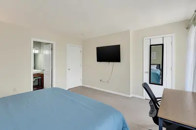 a bedroom with a bed and a tv on the wall at Chic Modern Townhouse 4BR 4B in Wilmington