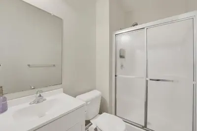 a white bathroom with a shower and a toilet at Chic Modern Townhouse 4BR 4B in Wilmington