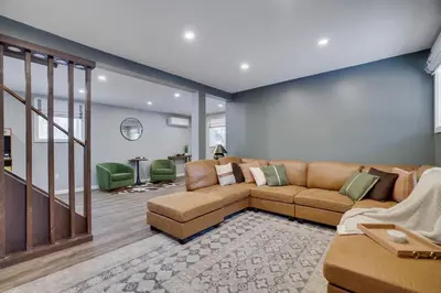 a large living room with a brown couch and green chairs at Cabin in the Woods in Wagners Forest Park
