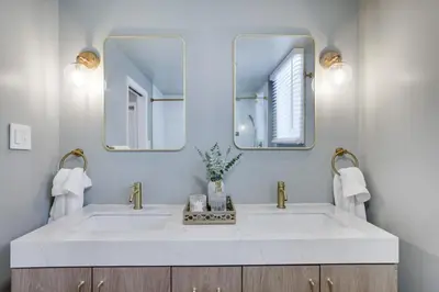 a bathroom with a white sink and two mirrors at Cabin in the Woods in Wagners Forest Park