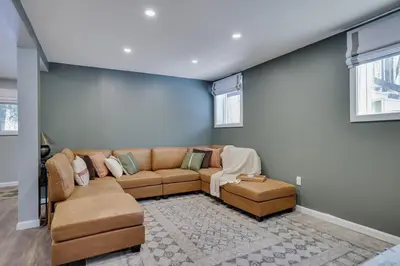 a living room with a brown couch and two ottoman at Cabin in the Woods in Wagners Forest Park