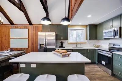 a kitchen with green cabinets and a white counter top at Cabin in the Woods in Wagners Forest Park