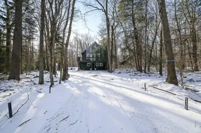 a house in the middle of a snow covered forest at Cabin in the Woods in Wagners Forest Park