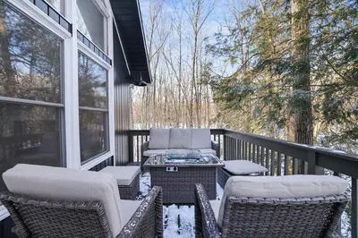 a porch with wicker chairs and a table on a balcony at Cabin in the Woods in Wagners Forest Park
