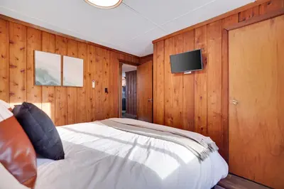 a bedroom with a bed and a tv on the wall at Cabin in the Woods in Wagners Forest Park
