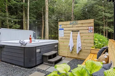 a bath tub in a garden with a wooden fence at Lazy Bear Retreat Outdoor Oasis Hot Tub etc in Blakeslee