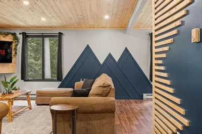 a living room with a couch and a blue wall at Lazy Bear Retreat Outdoor Oasis Hot Tub etc in Blakeslee
