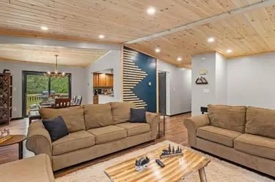 a living room with two couches and a table at Lazy Bear Retreat Outdoor Oasis Hot Tub etc in Blakeslee