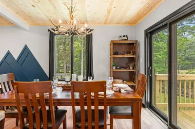 a dining room with a wooden table and chairs at Lazy Bear Retreat Outdoor Oasis Hot Tub etc in Blakeslee