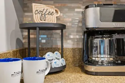 two coffee cups sitting on a counter next to a coffee maker at Lazy Bear Retreat Outdoor Oasis Hot Tub etc in Blakeslee