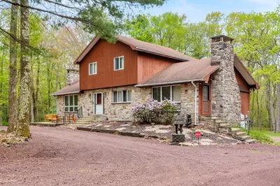 a house in the woods with a driveway at Pocono Retreat Hot Tub MovieRoom GameRoom etc in Lake Harmony