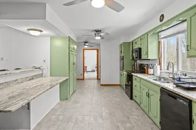 a kitchen with green cabinets and a ceiling fan at Pocono Retreat Hot Tub MovieRoom GameRoom etc in Lake Harmony