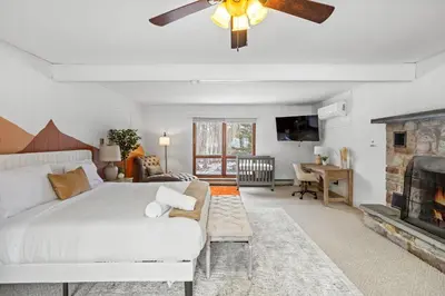 a bedroom with a white bed and a fireplace at Pocono Retreat Hot Tub MovieRoom GameRoom etc in Lake Harmony