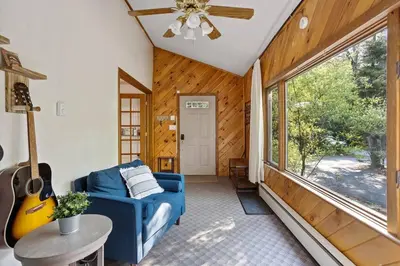 a living room with a blue couch and a guitar at Mountain Oasis Hot Tub Game Room Fire Pit in Pocono Summit