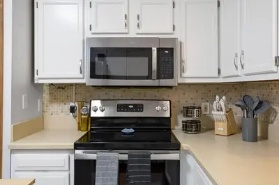 a kitchen with a stove and a microwave at Mountain Oasis Hot Tub Game Room Fire Pit in Pocono Summit