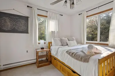 a bedroom with a large bed and two windows at Mountain Oasis Hot Tub Game Room Fire Pit in Pocono Summit