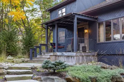a blue house with a front porch and stairs at Serene Whitetail Retreat Entertainment Galore in Long Pond