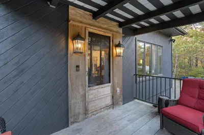a porch with a red couch on a deck at Serene Whitetail Retreat Entertainment Galore in Long Pond