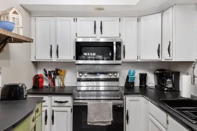 a kitchen with white cabinets and a microwave at Serene Whitetail Retreat Entertainment Galore in Long Pond