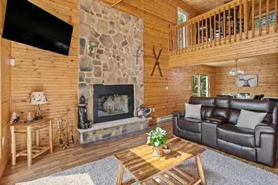 a living room with a couch and a fireplace at Rustic Retreat - Fire-pit Hot-Tub and more in Albrightsville