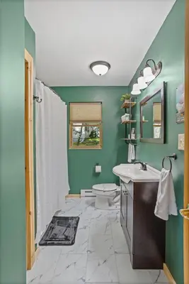 a green bathroom with a toilet and a sink at Rustic Retreat - Fire-pit Hot-Tub and more in Albrightsville