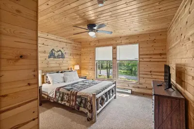 a bedroom with a bed and a ceiling fan at Rustic Retreat - Fire-pit Hot-Tub and more in Albrightsville