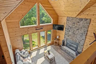 an overhead view of a living room with a large stone fireplace at Rustic Retreat - Fire-pit Hot-Tub and more in Albrightsville