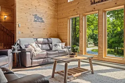 a living room with a leather couch and a coffee table at Rustic Retreat - Fire-pit Hot-Tub and more in Albrightsville