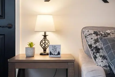 a table with a lamp on it next to a couch at Cozy Cinema Cabin - Hot Tub and More in Blakeslee