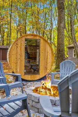 a circular wooden building with chairs and a fire pit at Whispering Pines - Lake Access Hot Tub Fire Pit in Blakeslee