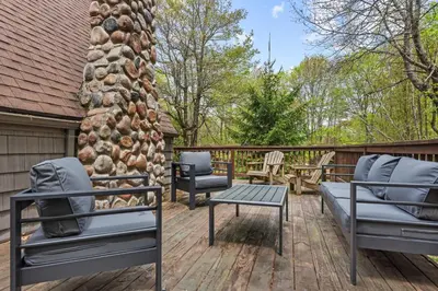 a patio with two chairs and a table on a deck at Whispering Pines - Lake Access Hot Tub Fire Pit in Blakeslee
