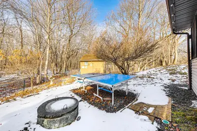 a ping pong table in the snow next to a building at Hot Tub and Game Room Long Pond Getaway! in Long Pond