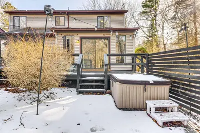 a house with a snow covered porch with a trash can at Hot Tub and Game Room Long Pond Getaway! in Long Pond
