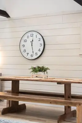 a clock on a wall above a wooden table at NewReno 8BR 6BTH DECK GAMES PETS in Lake Harmony