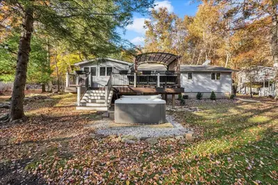 a home with a large porch and a house at Serene Pocono Escape Hot Tub Lake Access in Albrightsville