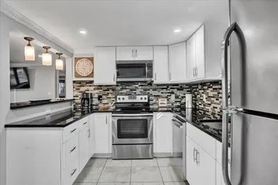 a kitchen with white cabinets and stainless steel appliances at Serene Pocono Escape Hot Tub Lake Access in Albrightsville
