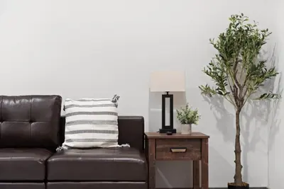 a brown leather couch sitting next to a table with a lamp at Twin Chalet 6 BDs Hot Tub Game Area and more in Albrightsville