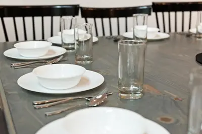a table with white plates and glasses and silverware at Twin Chalet 6 BDs Hot Tub Game Area and more in Albrightsville