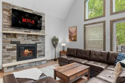 a living room with a couch and a fireplace at Twin Chalet 6 BDs Hot Tub Game Area and more in Albrightsville