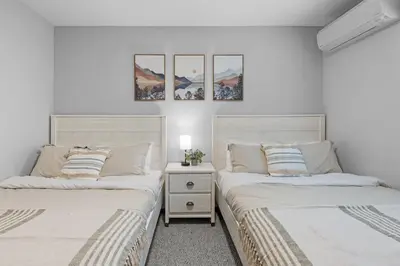 two beds sitting next to each other in a bedroom at Twin Chalet 6 BDs Hot Tub Game Area and more in Albrightsville