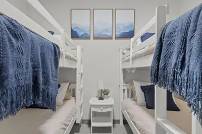 a room with two bunk beds with blue blankets at Twin Chalet - 6 BDs Hot Tub Game Area and more in Albrightsville