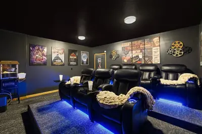 a movie room with black leather chairs and posters at Lakefront Movie & Game Rooms Hot Tub Sauna etc in Albrightsville