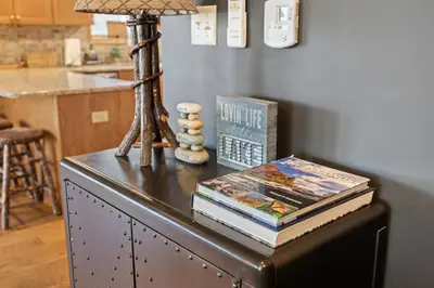 a table with books and a lamp on top of it at Lakefront Movie & Game Rooms Hot Tub Sauna etc in Albrightsville