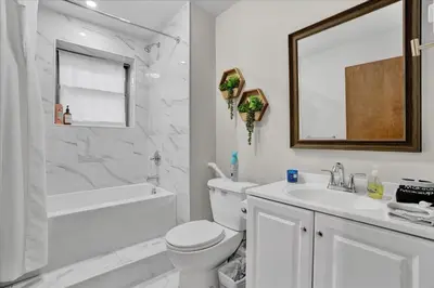 a white bathroom with a toilet and a sink at Mountain Holidays-Sleeps 18 Firepit Bar & Gameroom in Lake Harmony