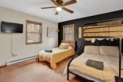 a bedroom with two bunk beds and a flat screen tv at Mountain Holidays-Sleeps 18 Firepit Bar & Gameroom in Lake Harmony