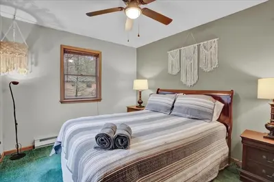a bedroom with a bed with towels on it at Mountain Holidays-Sleeps 18 Firepit Bar & Gameroom in Lake Harmony