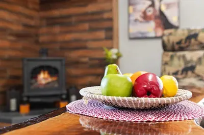 a bowl of fruit on a table with a fireplace at Cabin Oasis - Nestled in the Woods Seclusion in Blakeslee