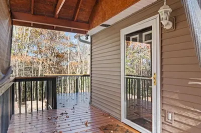a screened porch with a door to a house at Cabin Oasis - Nestled in the Woods Seclusion in Blakeslee